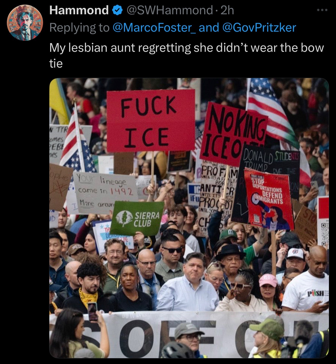 JB Pritzker standing in a crowd of protestors with the caption, "My lesbian aunt regretting she didn’t wear the bow tie."